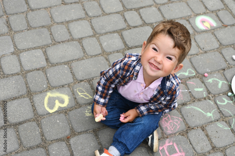 Portrait of smiling toddler boy on the background of chalk drawings. Portrait of smiling toddler boy on the background of chalk drawings.