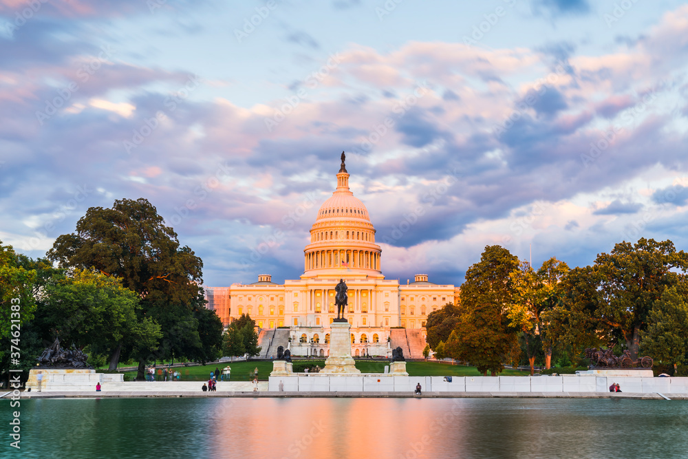 Obraz premium The United States Capitol building at sunset wirh reflection in water.