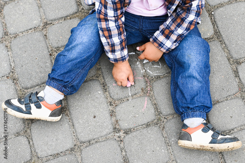 cropped legs and hands of a little boy, top view