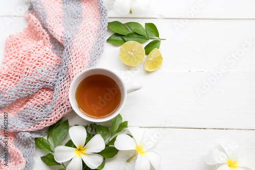 herbal healthy drinks hot lemon tea for health care sore throat with knitting yarn  ,flowers frangipani arrangement flat lay style on background white wooden
