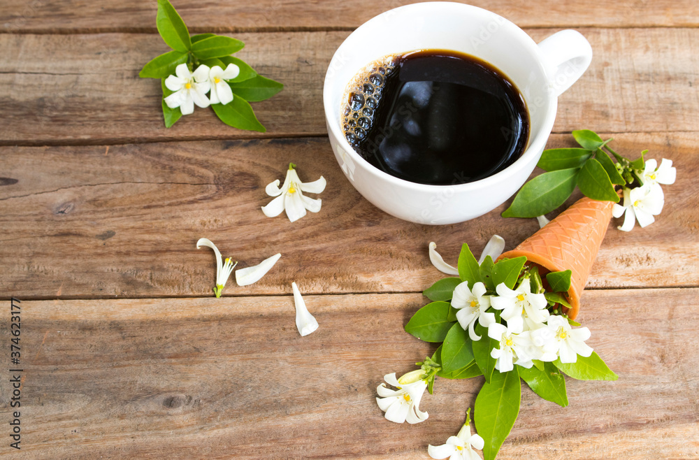Fototapeta premium white flowers jasmine local flora of asia in cone and hot coffee espresso arrangement flat lay postcard style on background wooden