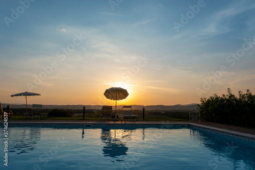 Swimming pool entrance and colourful sun loungers