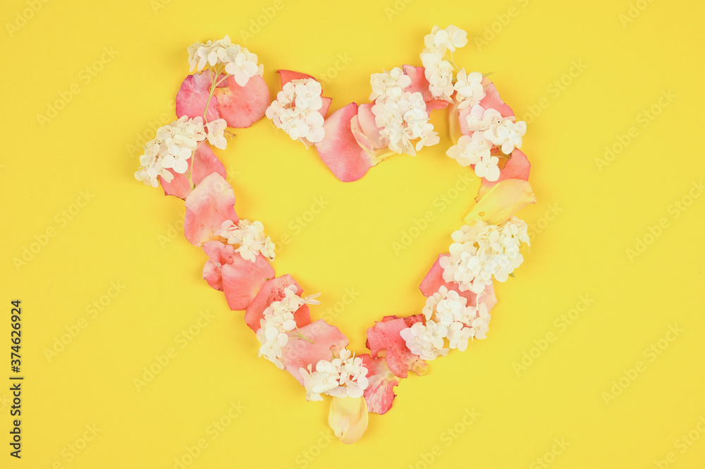  Heart made of petals on a yellow background.