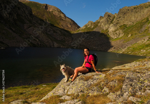 young woman with her dog in a mountain lake