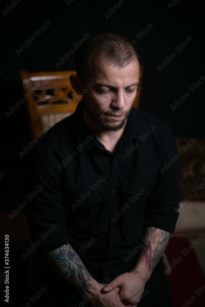 Obraz premium sad guy sitting on black background