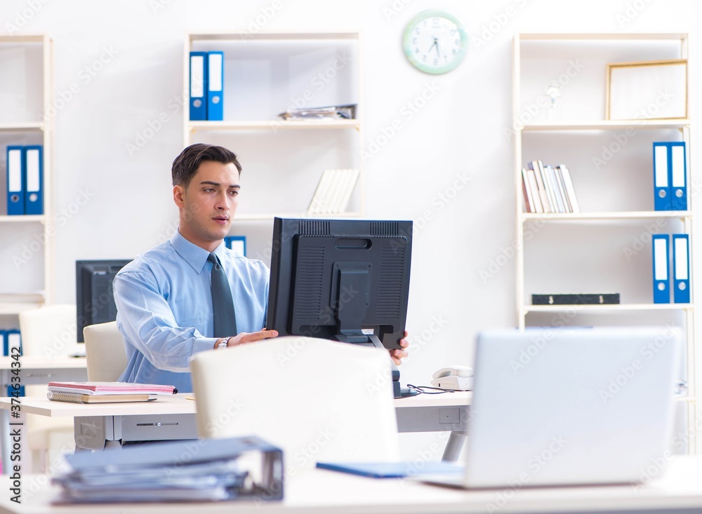 Handsome businessman employee sitting at his desk in office Handsome businessman employee sitting at his desk in office