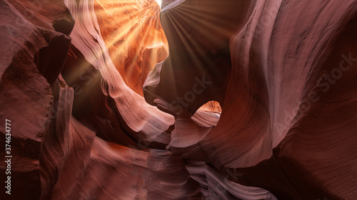 A ray of light streams from The Eye in Antelope Canyon. Abstract background concept. Sunlight in the famous Antelope Canyon near page, arizona, usa.