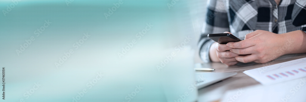 Fototapeta premium Female hands using a smartphone; panoramic banner