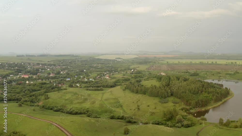 Scenic aerial panoramic view of idyllic rolling hills spring landscape in with lush green mountain pastures in evening light at sunset