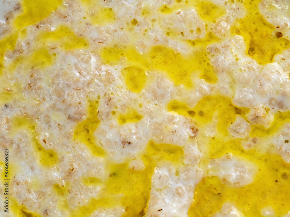 Appetizing porridge made from fresh milk with the addition of vegetable oil or butter. The texture of the surface of the porridge completely fills the food background. Appetizing porridge made from fresh milk with the addition of vegetable oil or butter. The texture of the surface of the porridge completely fills the food background.