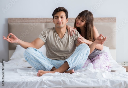 Young family meditating in the bed bedroom