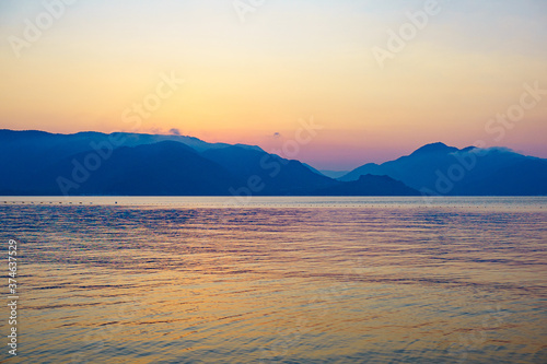  pink orange sunrise over blue sea and mountains