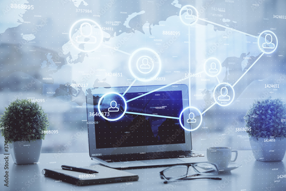 Computer on desktop with social network hologram. Double exposure. Concept of international people connections. Computer on desktop with social network hologram. Double exposure. Concept of international people connections.