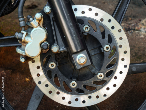 close up of motorcycle wheel with disc brake and caliper.