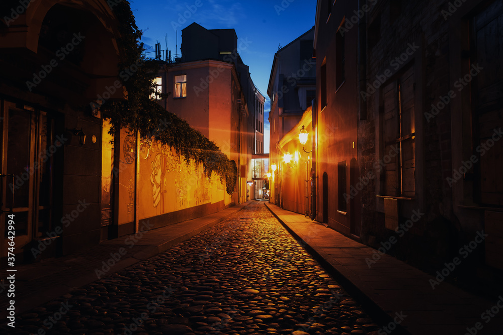 City night landscape, street with paving stones in the historic center of Vilnius, Lithuania, travel to the Baltic countries
