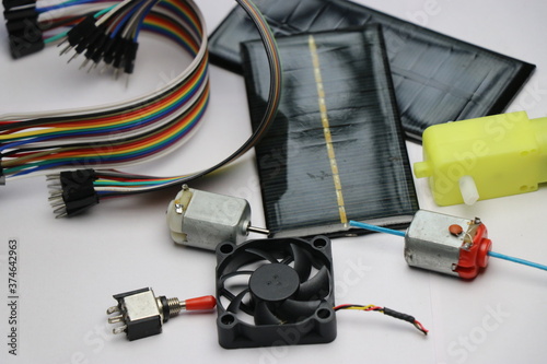 Electronic componets kit having solar panels,dual shaft dc motor,dc toy motor,dc gear motor,double shaft motor,motor controller,pc fan,switch and jumper wires on white background