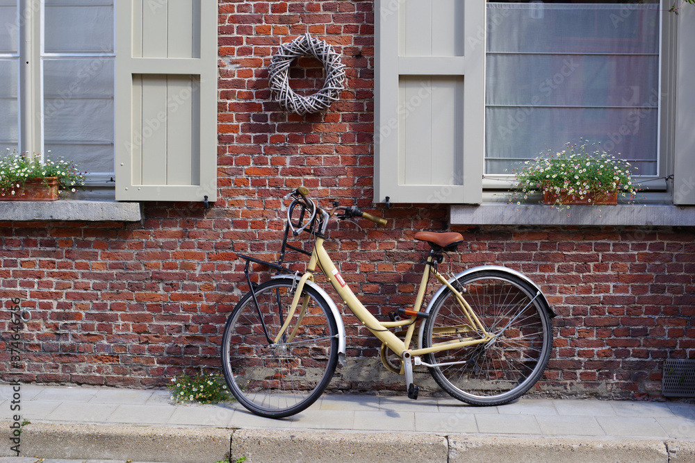 Vélo devant une maison aux fenêtres fleuries