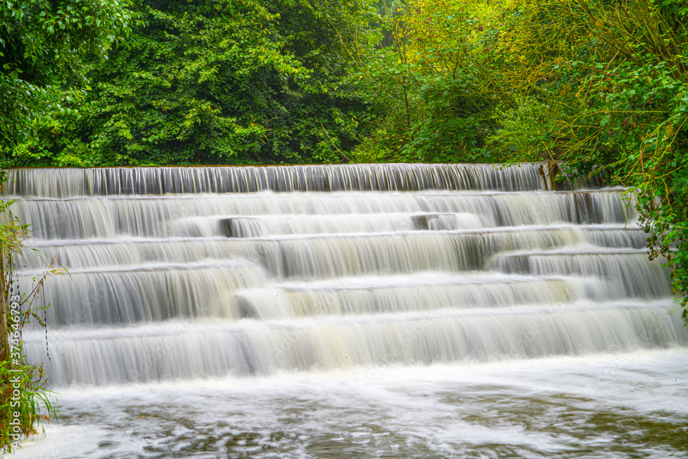 White Water flowing over weir low-level view at long exposure for blurred water effects and textures White Water flowing over weir low-level view at long exposure for blurred water effects and textures