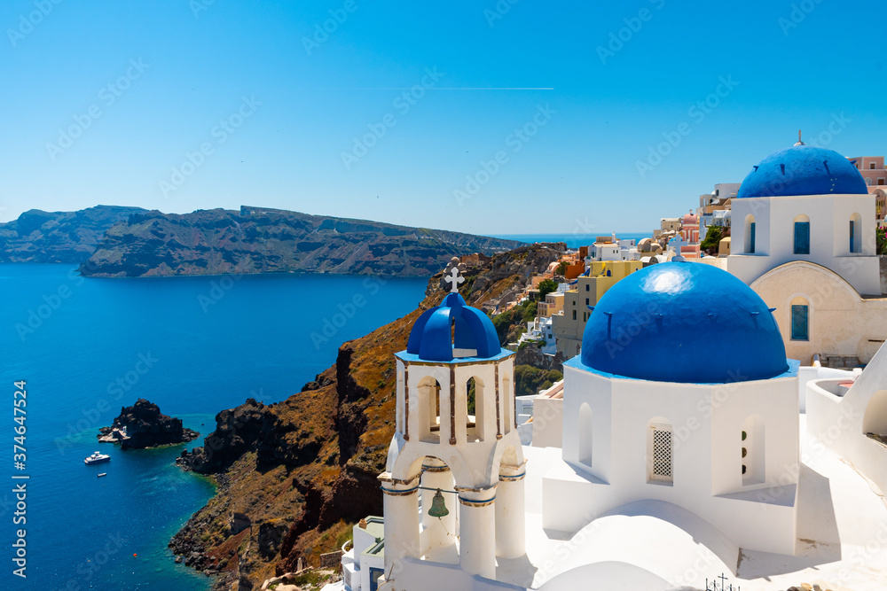 Iconic View of churches with blue rooftops in Santorini, Greece, in the town of Oia. 