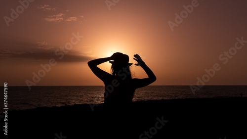 Silhouette of a woman with hat during sunset