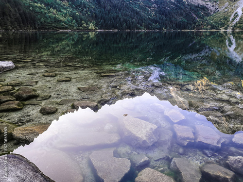 Glasklares Wasser mit Spiegelung der Berge