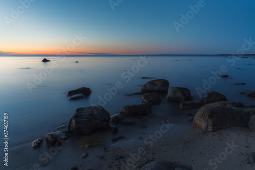 Sea shore and rocks at the sunset, cold blue sky. Nature composition. photo