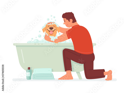 Happy man washes the dog in the bathroom. The guy takes care of his pet. Hygiene home animal