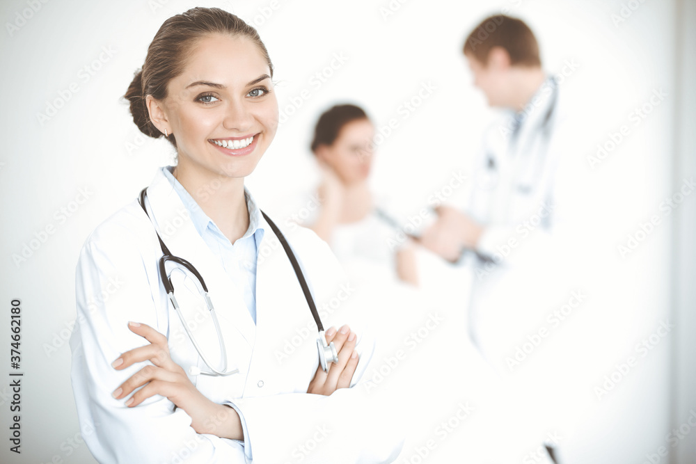 Cheerful smiling woman-doctor on the background of his patient in the bed. Medicine concept Cheerful smiling woman-doctor on the background of his patient in the bed. Medicine concept
