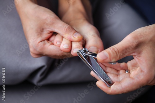 Man cuts his toenails with a Clipper