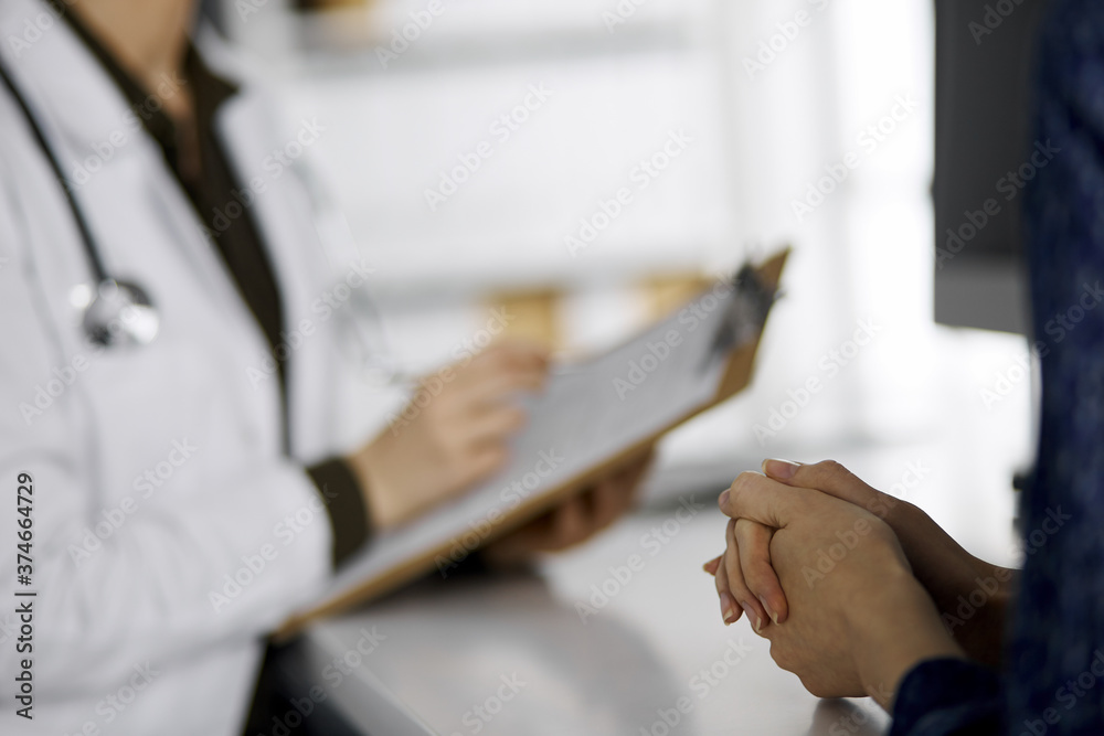 Obraz premium Doctor and patient discussing current health examination while sitting in clinic. Perfect medical service in hospital. Medicine concept