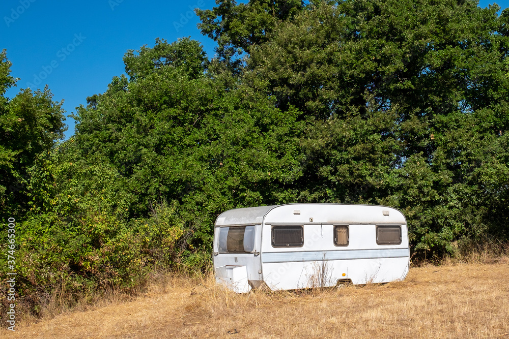old abandoned caravan in a dry lawn. Lake Bolsena, lazio , Italy old abandoned caravan in a dry lawn. Lake Bolsena, lazio , Italy