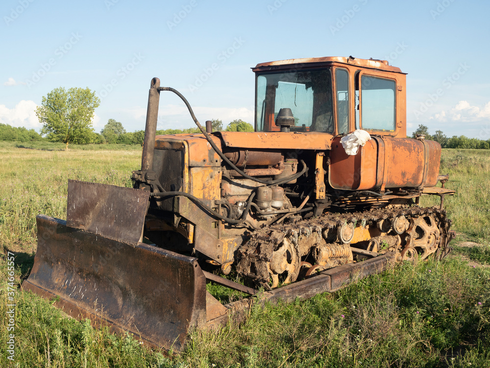 Old rusty tractor on tracks. Old farm equipment Old rusty tractor on tracks. Old farm equipment