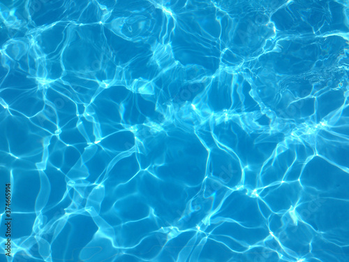 Blue water of a swimming pool in summer with reflections of sunlight in rippling waves