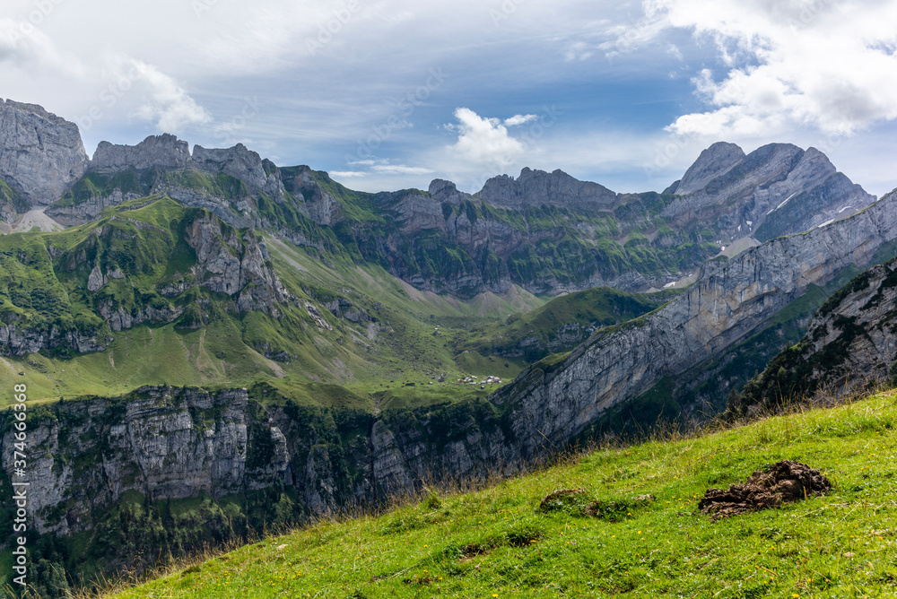 The Meglisalp village in Appenzell, Switzerland sitting betweeen the tall peaks of the Alpstein range in the Swiss Alps