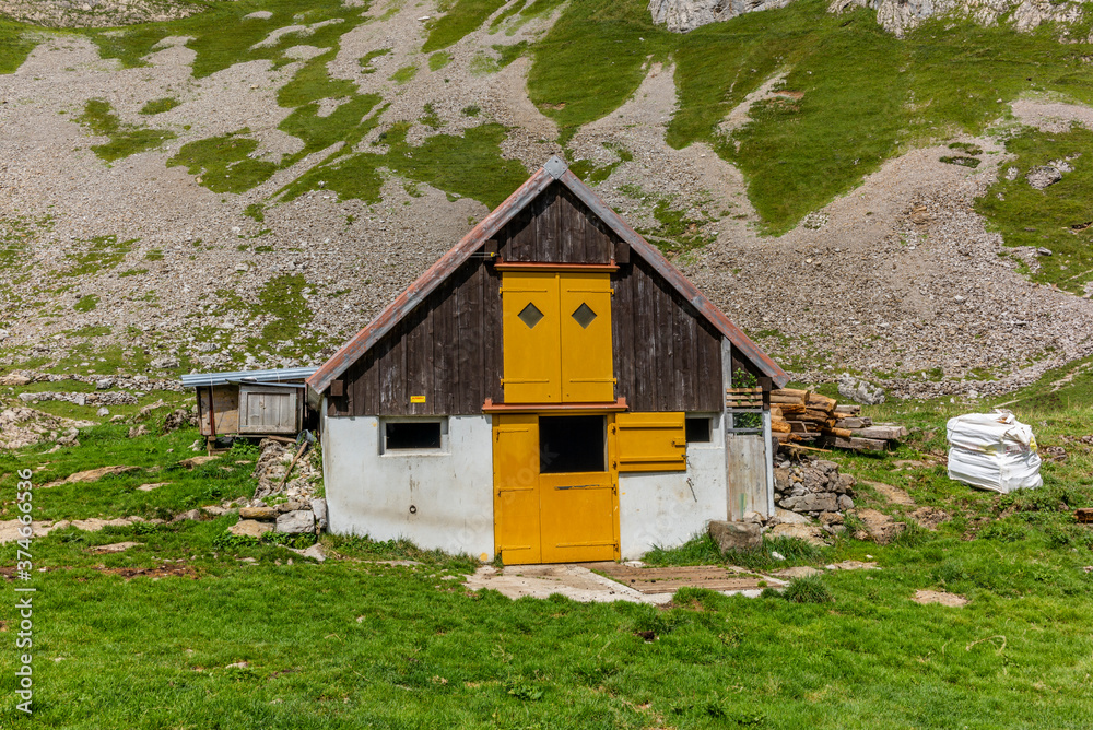 Old log stable on the alpine meadows covered in green grass in the Appenzell canton of Switzerland Old log stable on the alpine meadows covered in green grass in the Appenzell canton of Switzerland