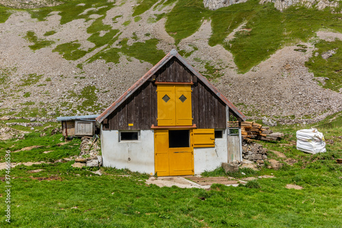 Old log stable on the alpine meadows covered in green grass in the Appenzell canton of Switzerland