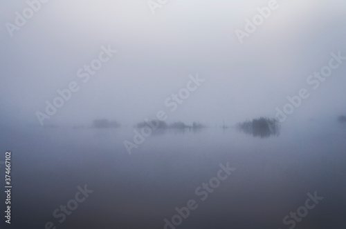 Morning fog before sunrise over a forest lake