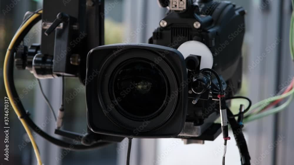 Film crew in outdoor studio shooting video. Camera on crane jib. Filmmaking industry.