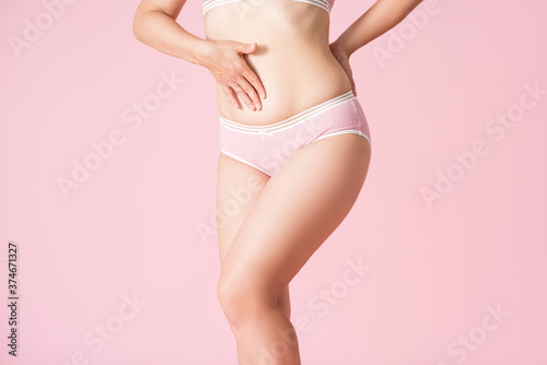 Slim woman in underwear on pink background