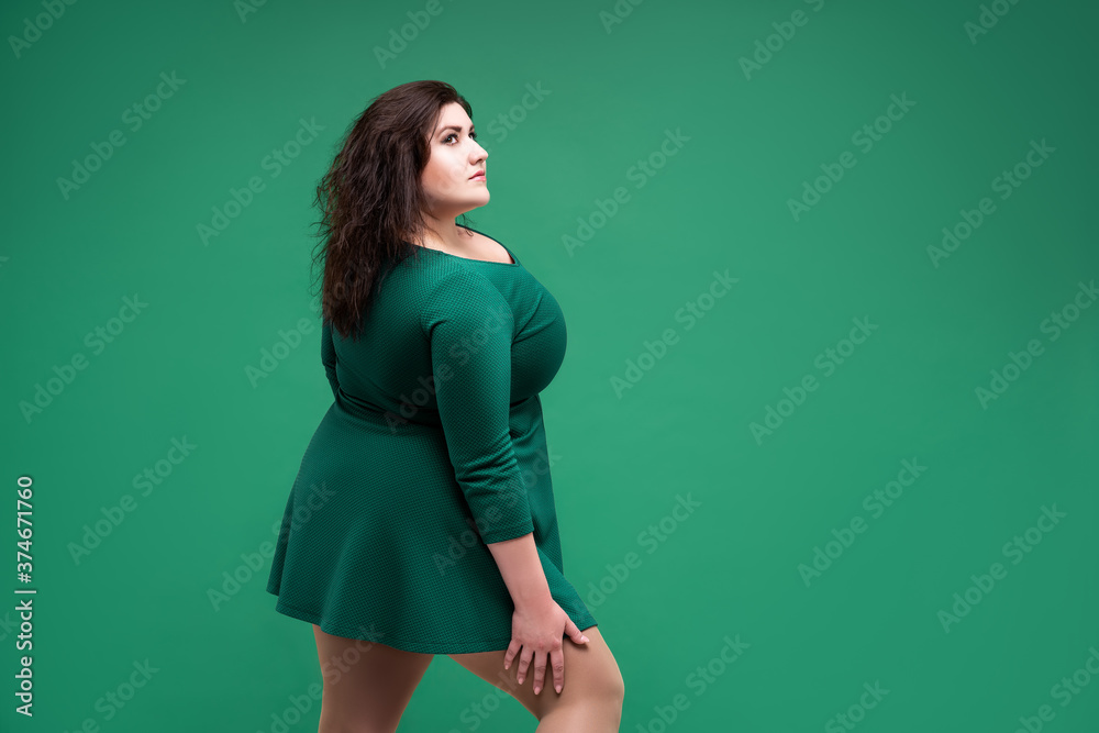 Plus size fashion model in green dress, fat woman on green background, body positive concept Plus size fashion model in green dress, fat woman on green background, body positive concept