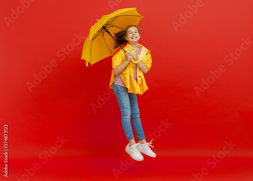 Kid with umbrella on colored background.