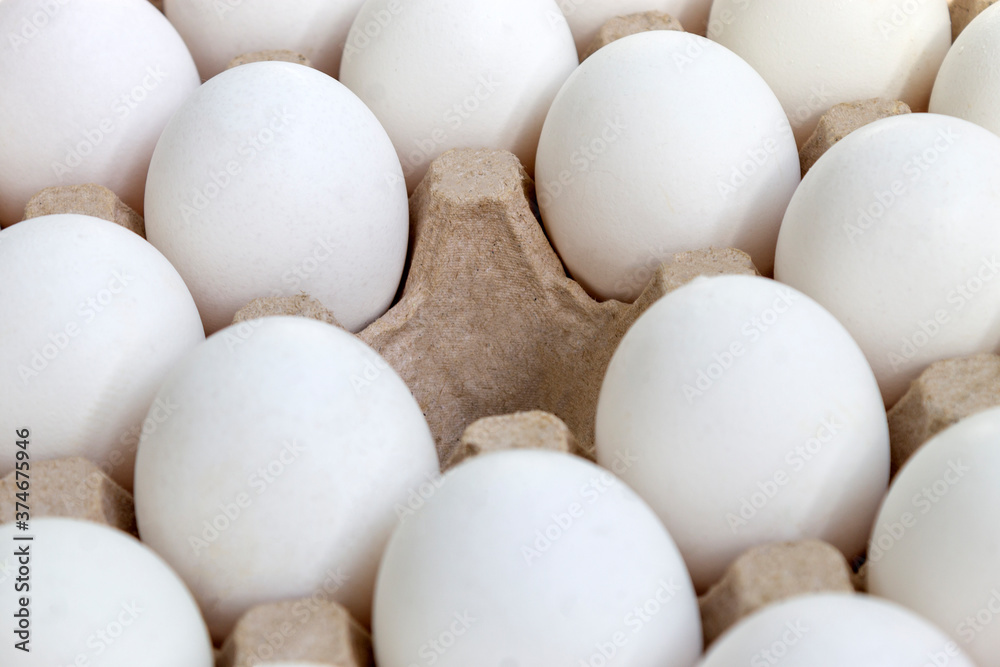 Texture background even rows of white chicken eggs in a cortnon box with one empty cell with daytime cloudy light Texture background even rows of white chicken eggs in a cortnon box with one empty cell with daytime cloudy light