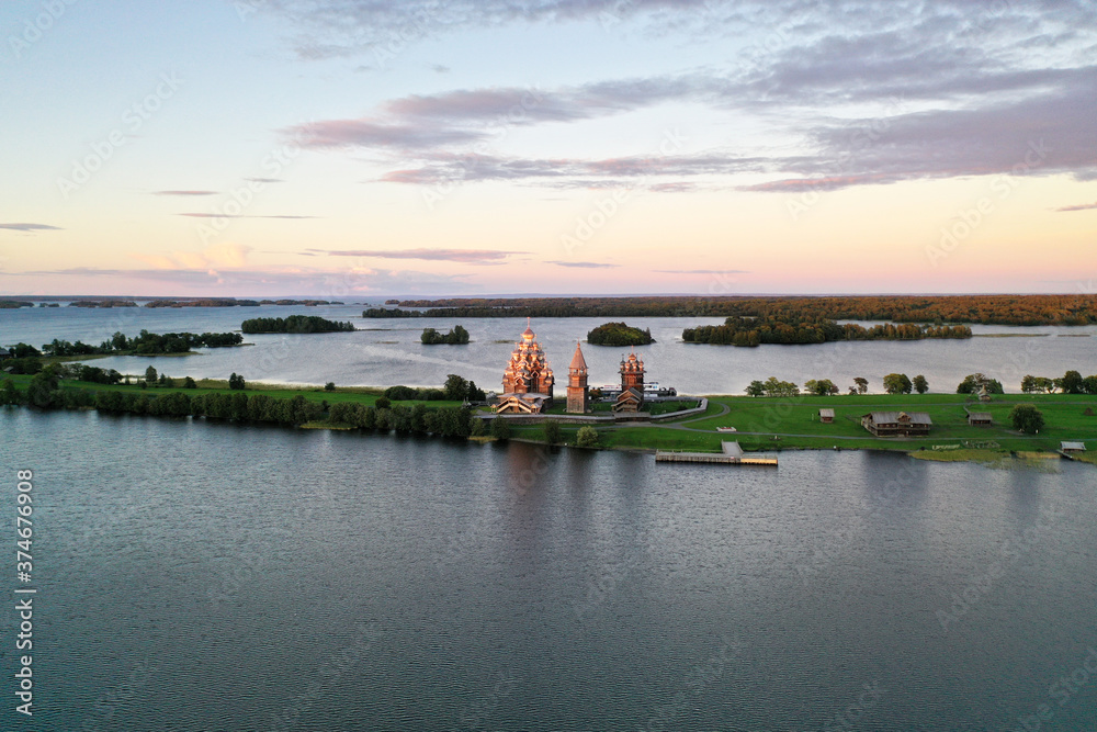 Fototapeta premium a panoramic view of the green islands on the lake with ships with ancient architectural buildings filmed from a drone