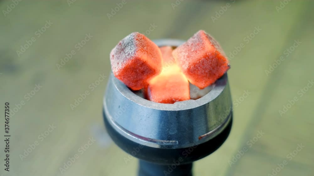 Closeup of burning embers on hookah. Media. Square red coals ignite