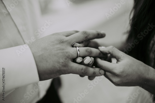 The bride and groom exchange wedding rings. Hands from a close distance.