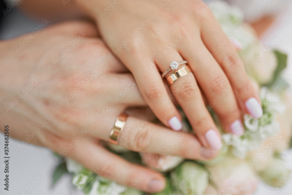 Hands of the newlyweds. Bride and groom holding hands at the wedding ceremony. Wedding rings on the hands of the newlyweds. Hands of the newlyweds. Bride and groom holding hands at the wedding ceremony. Wedding rings on the hands of the newlyweds.