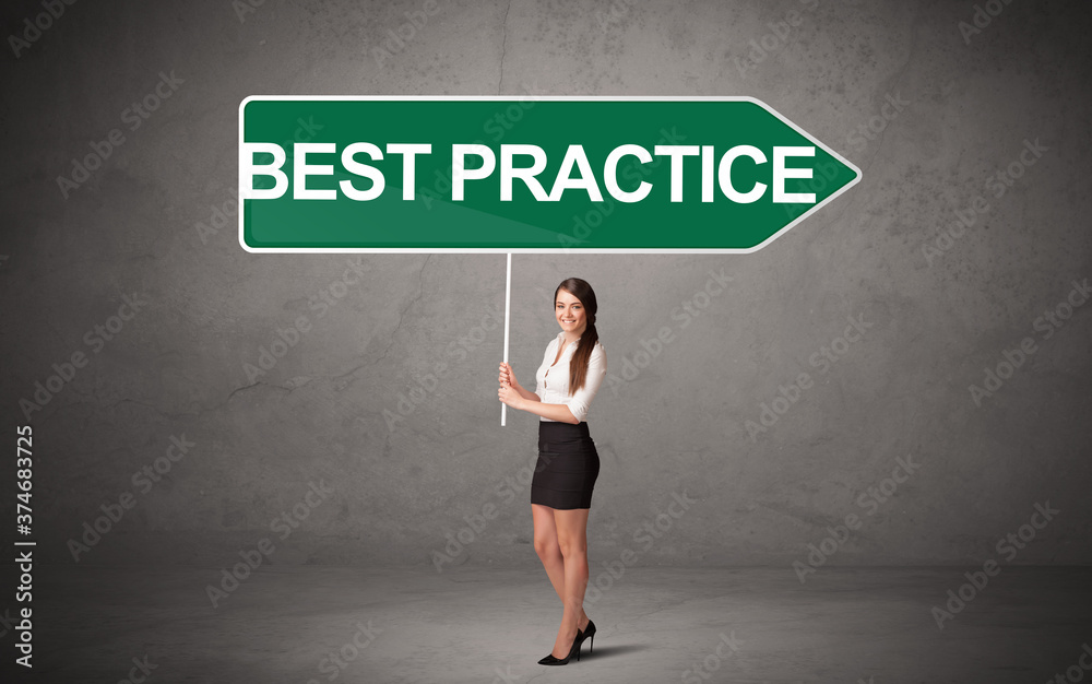 Young business person in casual holding road sign with BEST PRACTICE inscription, new business direction concept Young business person in casual holding road sign with BEST PRACTICE inscription, new business direction concept