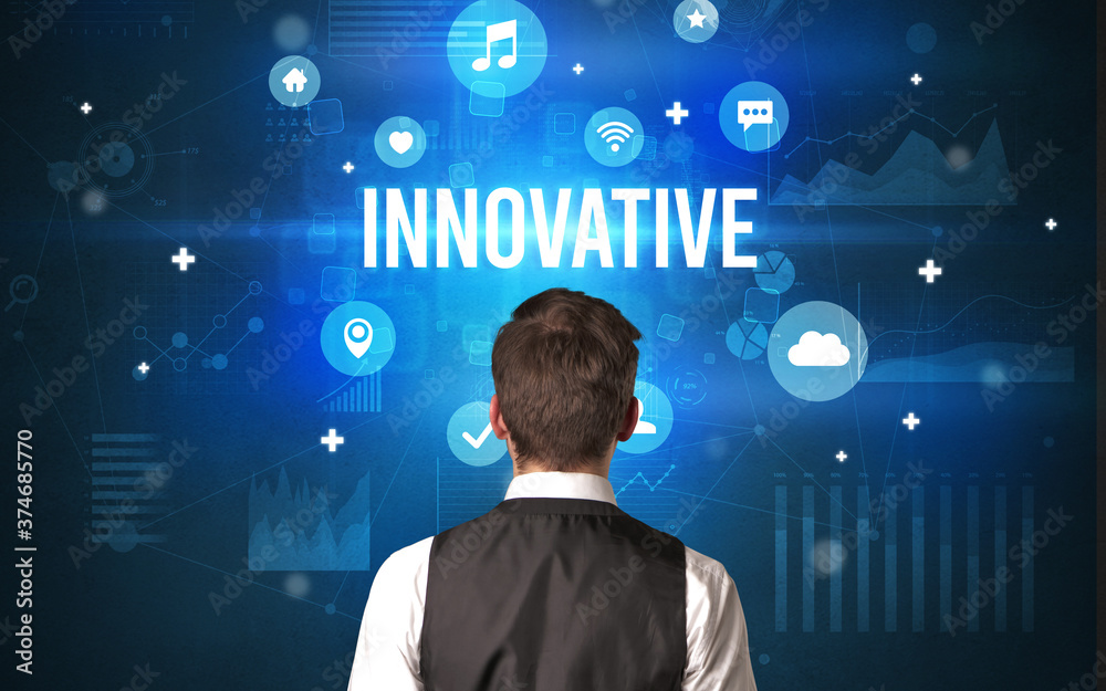 Rear view of a businessman with INNOVATIVE inscription, modern technology concept Rear view of a businessman with INNOVATIVE inscription, modern technology concept