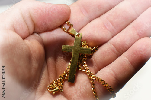 Gold Jesus Christ Cross In Palm Of Hands Close Up