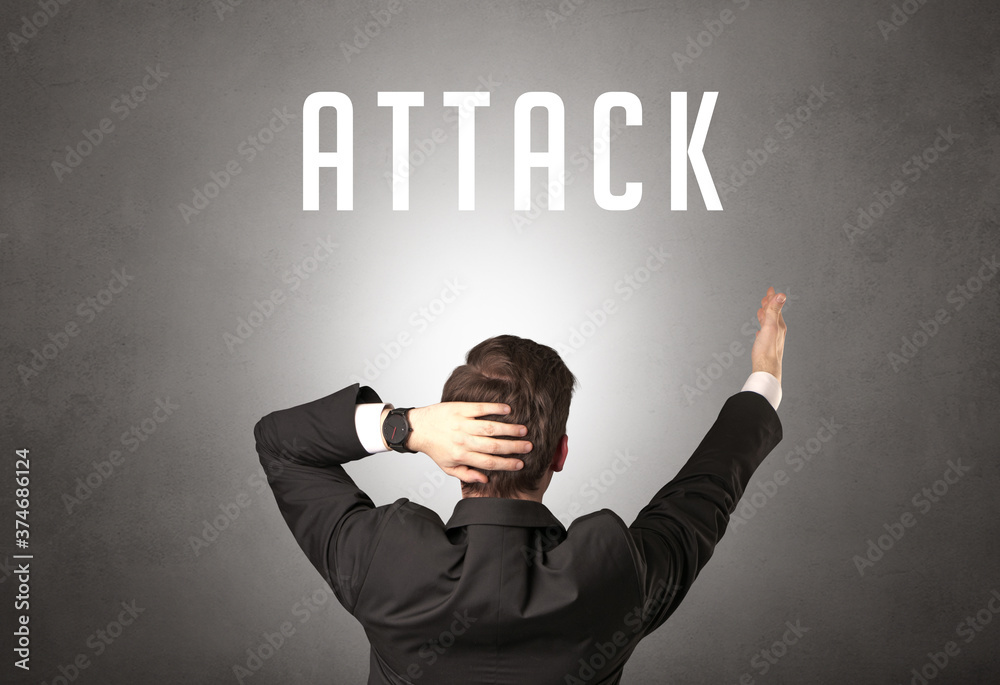 Rear view of a businessman with ATTACK inscription, cyber security concept Rear view of a businessman with ATTACK inscription, cyber security concept